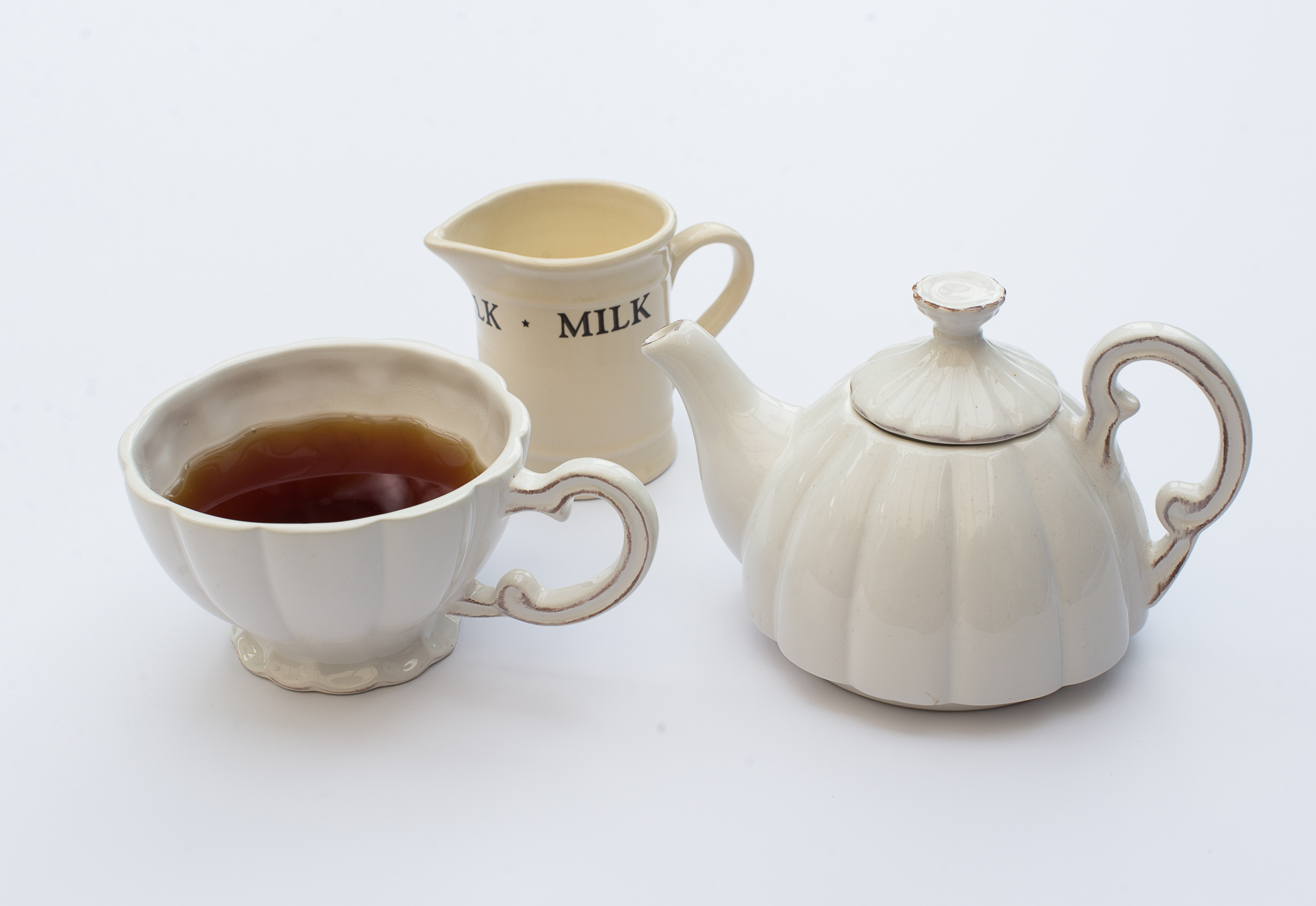 A cup of black tea with milk jug and tea pot by www.englishcreamtea.com